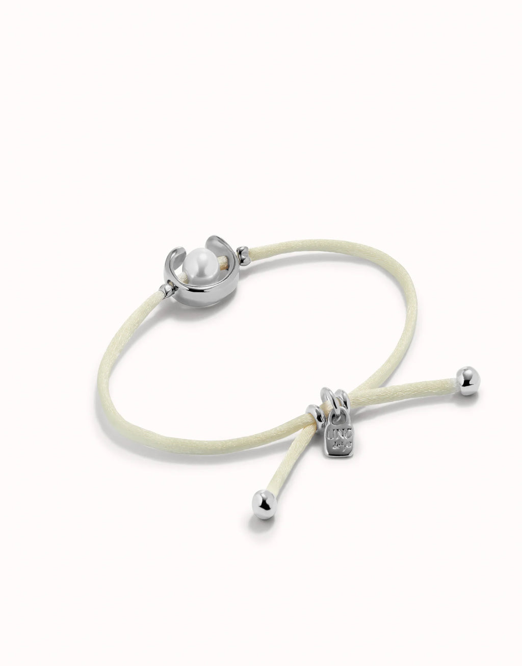 UNO DE 50 - Pulsera de hilo crema con perla shell fornitura bañada en plata de ley.
