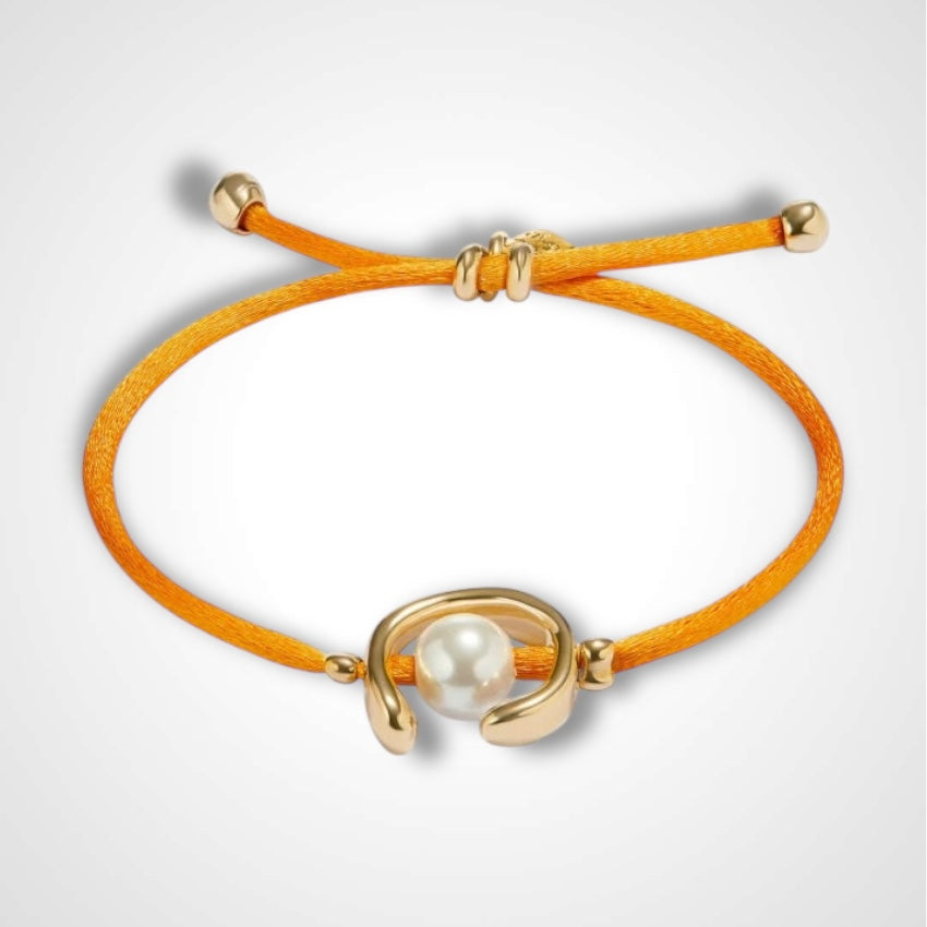UNO DE 50 - Pulsera de hilo naranja con perla shell fornitura bañada en oro.